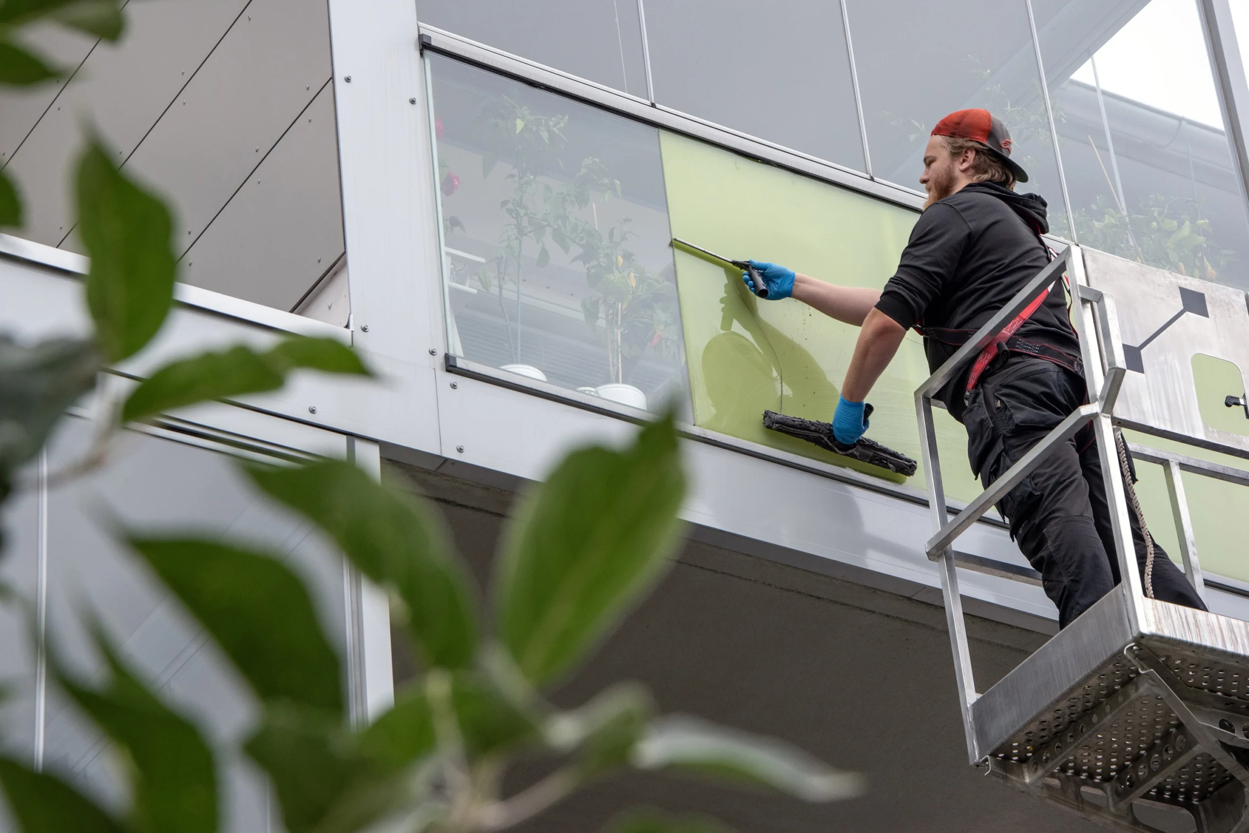 Compiten työntekijä tekee ikkunanpesun nostolaitteistosta.